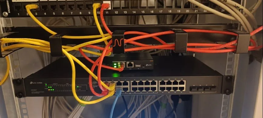 Netwerkkast met gele patchkabels bij Fysio Bladel